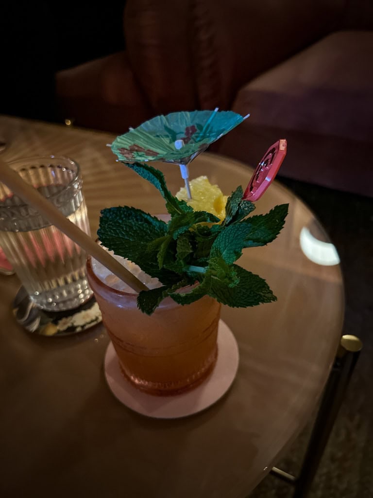 Tropical cocktail with pineapple wedge, drink umbrella, and pineapple leaves for garnish