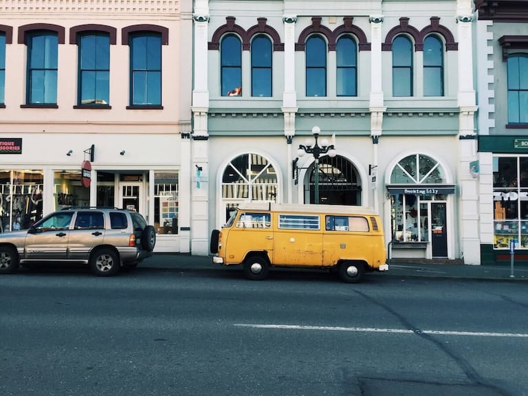 yellow van parked in front of pastel buildings on johnson street in victoria bc