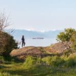 hiker on a bluff overlooking the salish sea in victoria bc